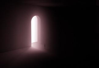 silhouette of person standing near a doorway with bright light